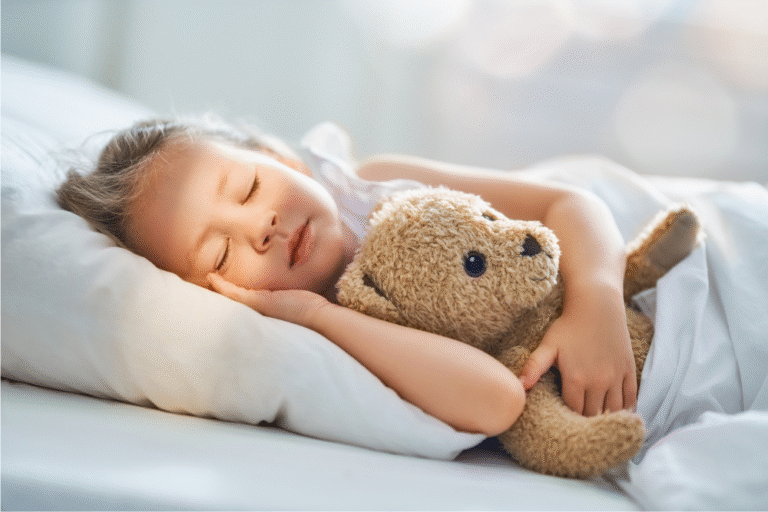Enfant qui dort paisiblement avec son doudou, séance de sophrologie pour favoriser le sommeil et l'endormissement