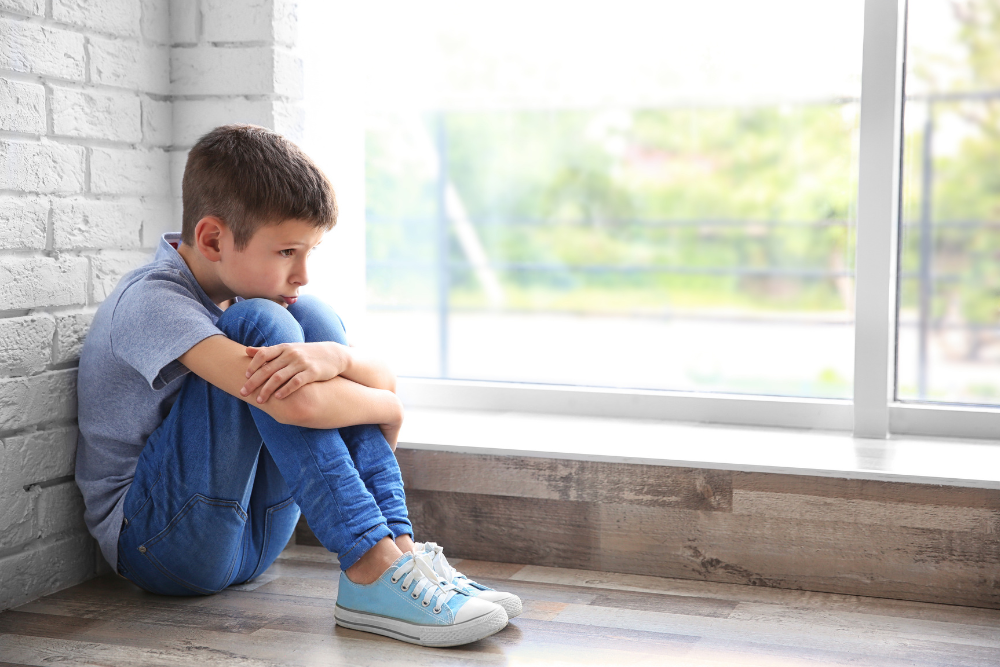 Petit garçon triste assis seul, illustration de l'accompagnement du deuil chez l'enfant en sophrologie